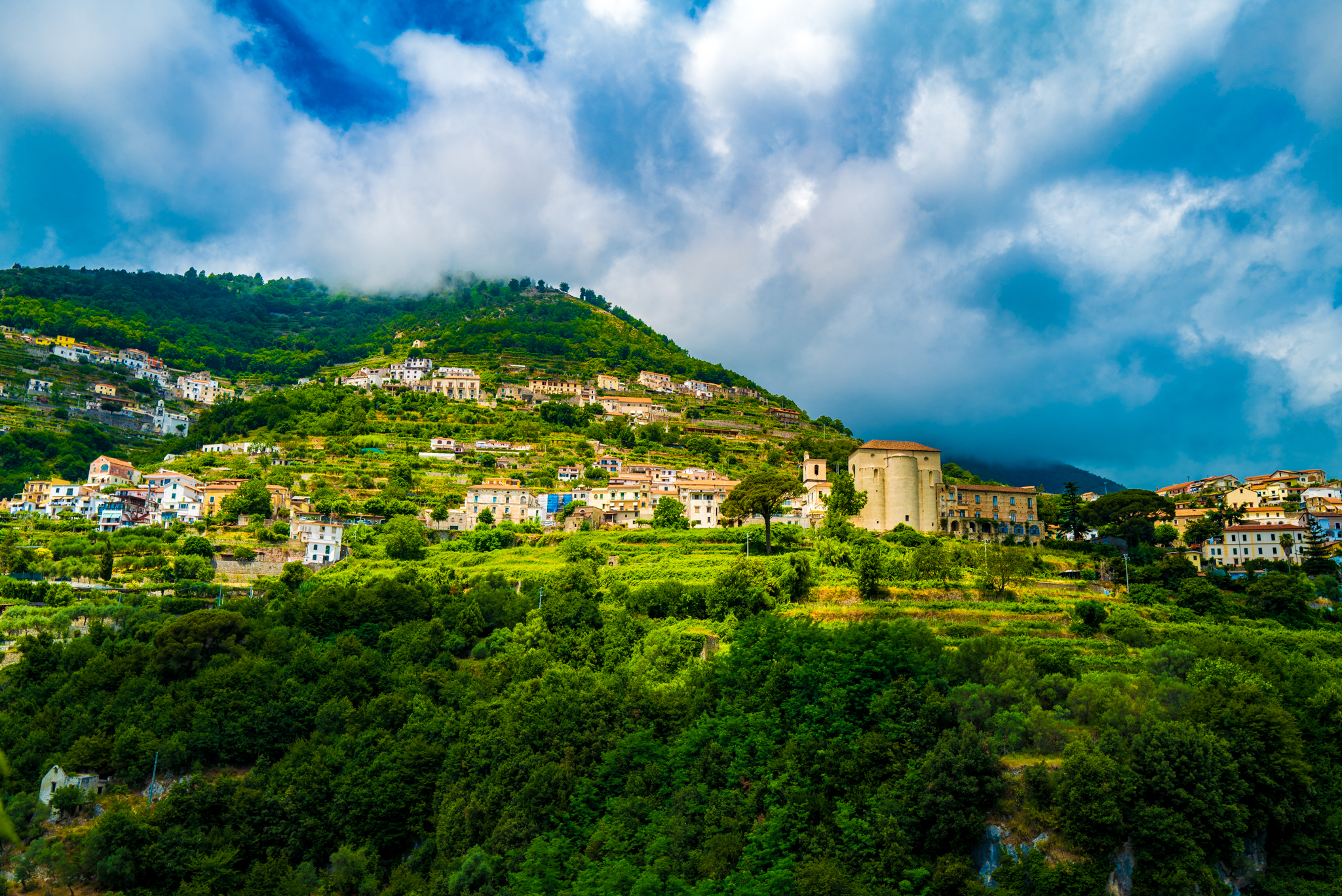 A photo looking up at the mountain in Amalfi on a partly cloudy day.