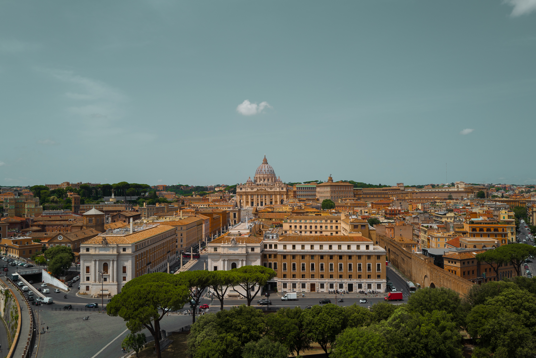 St. Peter's Basilica, viewed from afar, with a single cloud above it.